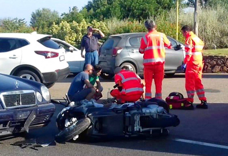 Ambulance personnel tend to a man lying on the ground, later identified as actor George Clooney, after being involved in a scooter accident in the near Olbia, on the Sardinia island, Italy, Tuesday, July 10, 2018. Actor George Clooney was taken to the hospital in Sardinia on Tuesday and released after being involved in an accident while riding his motor scooter, hospital officials said. “He is recovering at his home and will be fine,” spokesman Stan Rosenfield told The Associated Press in an email. The John Paul II hospital in Olbia confirmed Clooney had been treated and released after Tuesday’s accident. Local media that had gathered at the hospital said Clooney left in a van through a side exit. (AP Photo/Mario Chironi)