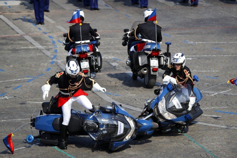 Two police motorcycles crash during a demonstration as part of the Bastille Day parade on the Champs Elysees avenue in Paris, France, Saturday, July 14, 2018. France's military is marching through Paris for Bastille Day celebrations and getting a budget boost from President Emmanuel Macron. (AP Photo/Francois Mori)