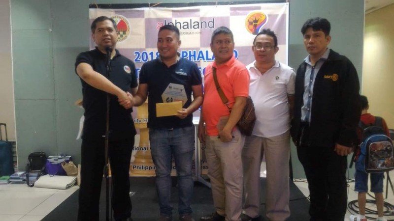 National Master (NM) lawyer Bob Jones Liwagon of the Philippine Army (second from left) receive his top prize P10,000 plus elegant trophy to Philippine Executive Chess Association (PECA) founding president Atty. Cliburn Anthony A. Orbe (first from left) for winning the  sixth leg Alphaland National Executive Chess Championship was held last June 30, 2018 at the Activity Hall, Second Floor, Alphaland Makati Place in Malugay Street, Makati City .Also in photo were IT expert Joselito Cada, 7-times Philippine Executive Champion Dr. Jenny Mayor and Dr. Alfredo "Fred" Paez.