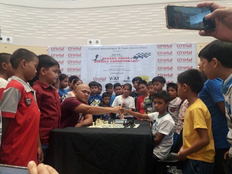 A file photo shows Mr. Ernie Abanco of Abanco Realty (left) shakes hand with his young opponent,  before making the ceremonial moves to kick off the Negros Kiddies Chess Championship last year held in Bacolod City.
