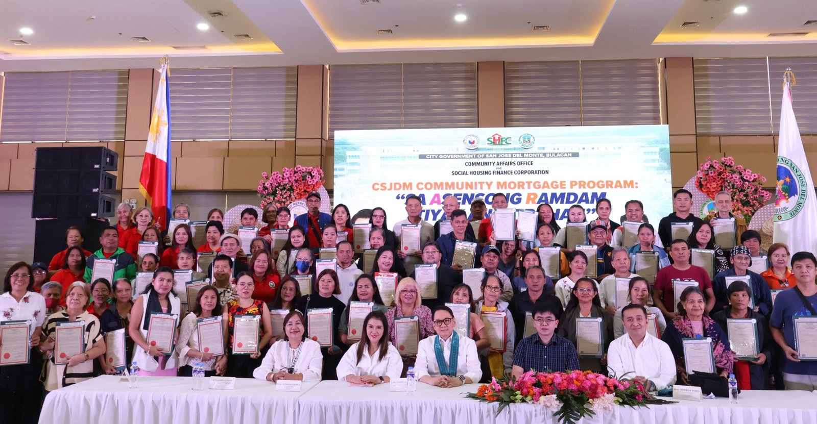 Beneficiaries receive their Transfer Certificates of Title from SHFC officials in Bulacan.
