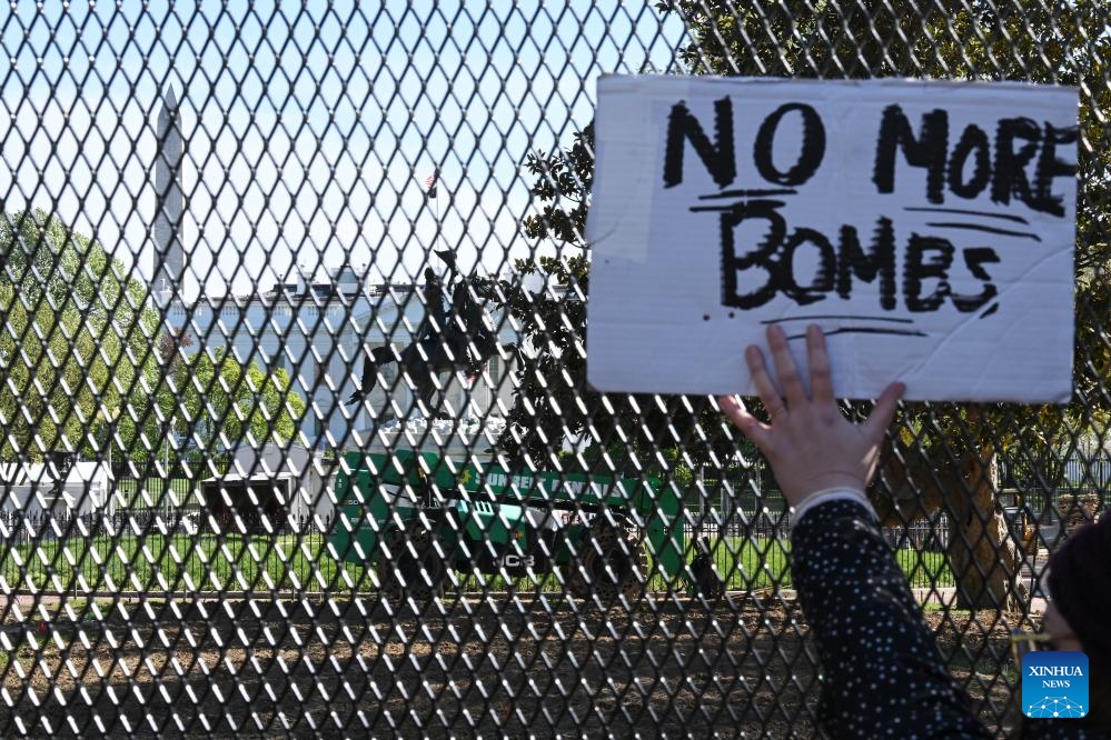 A demonstrator holds a placard in front of the White House in Washington, D.C., the United States, on April 7, 2026. (Xinhua/Li Rui)