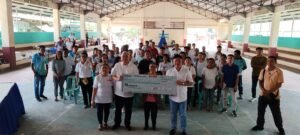 Government officials present housing assistance checks to beneficiaries