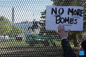 A demonstrator holds a placard in front of the White House in Washington, D.C., the United States, on April 7, 2026. (Xinhua/Li Rui)
